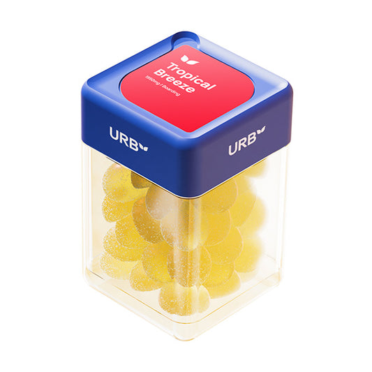 Urb Boarding Skybites Gummies in clear jar with blue lid, featuring 30 yellow tropical-flavored gummies. Product label shows 'Tropical Breeze' flavor. High-potency CBD gummies with 65mg per piece, totaling 1950mg per container.